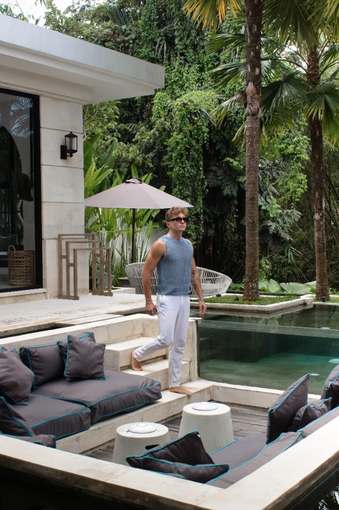 Lukas walking through a tropical villa outdoor space