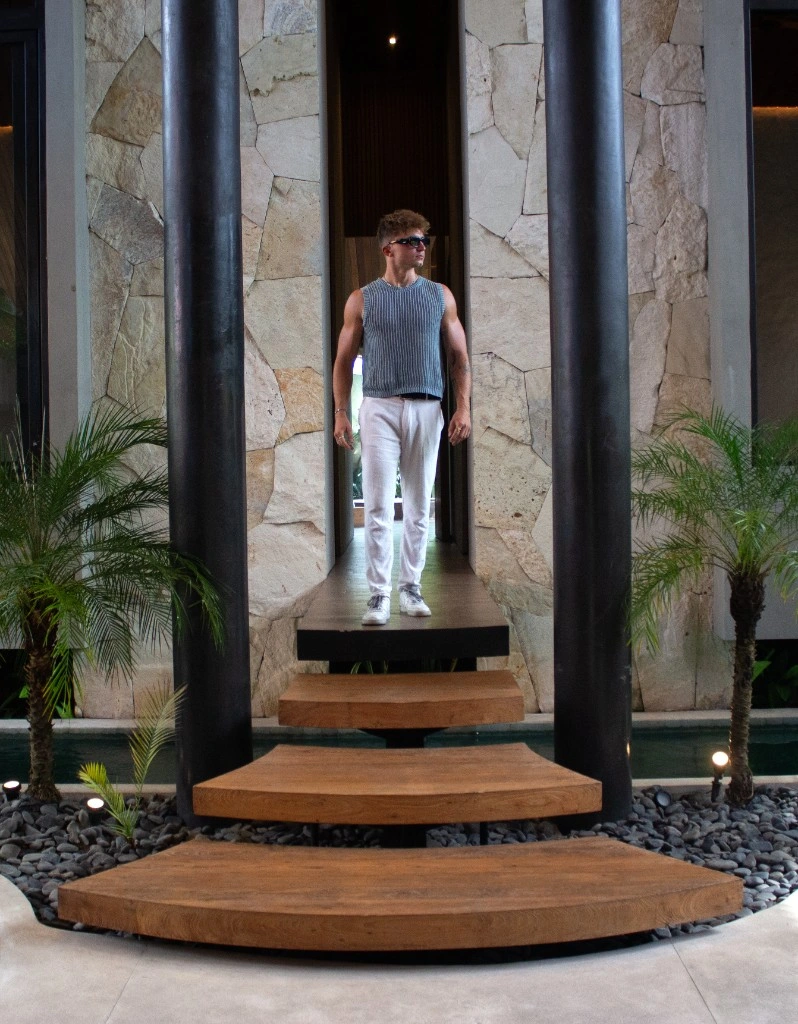 Lukas at a luxury villa entrance with stone walls