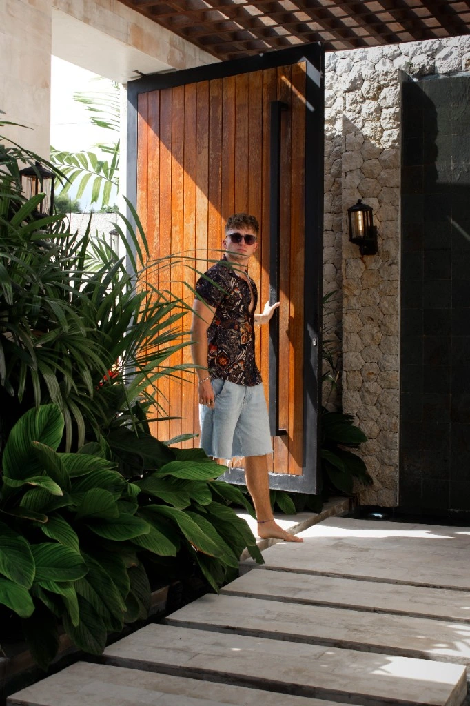 Lukas at a villa doorway with tropical greenery