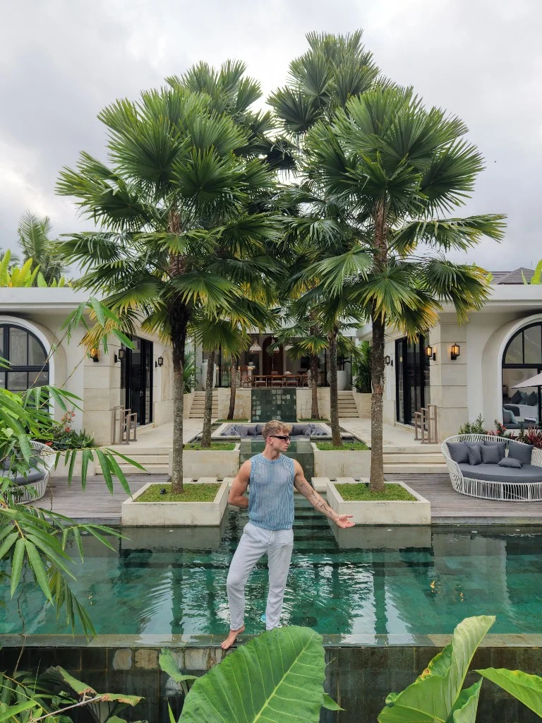 Lukas in a pool at a white arched tropical villa