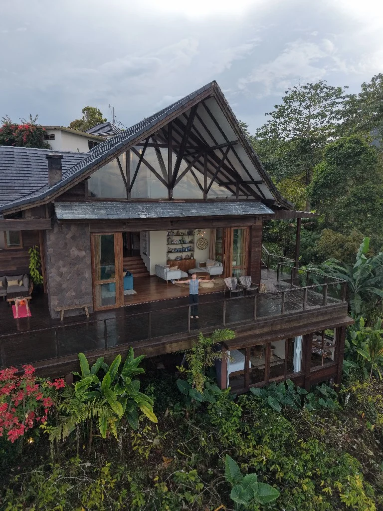 Lukas on a wooden villa balcony above the jungle